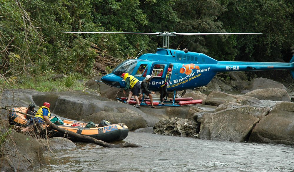 Photo showing a helicopter dropping off rafters and equipment at the Put In for whitewater rafting adventures down the Noth Johnstone River 