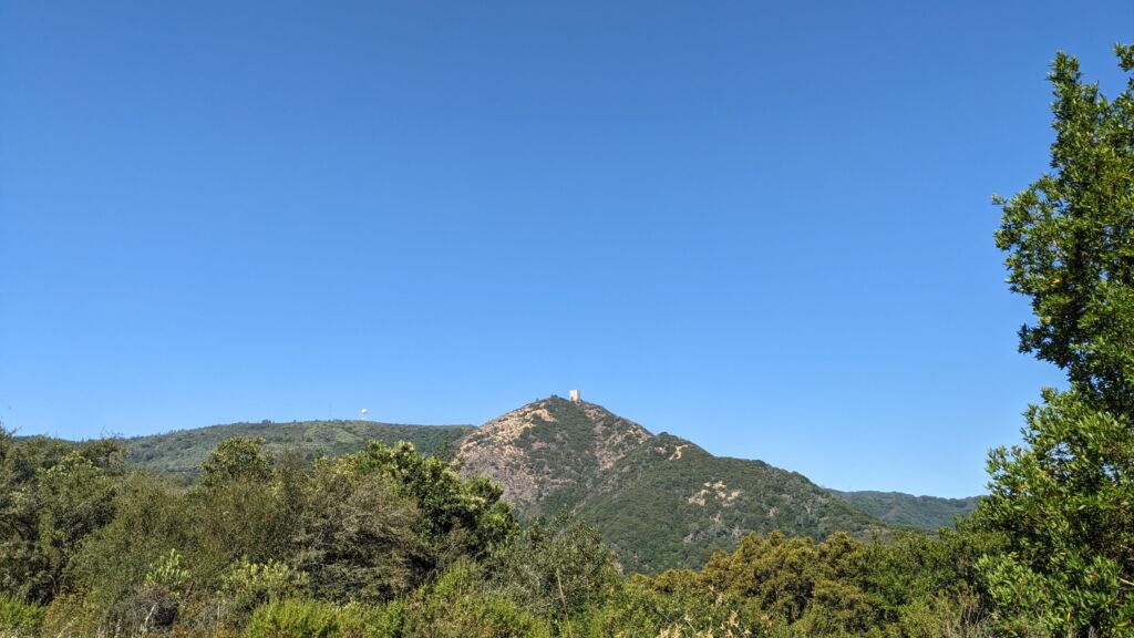 A view along a mountain road of “The Cube” on top of Mount Umunhum on a sunny day.