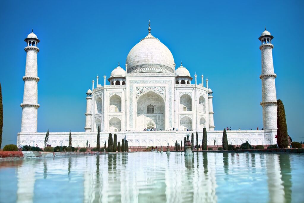 Taj Mahal in soft daylight with a clear blue sky behind the famous facade