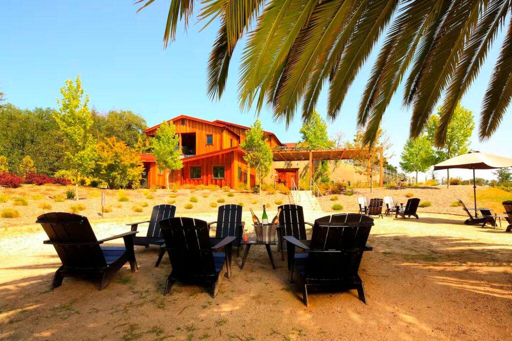 Photo showing the building of Cast Estate Winery with a seating for tastings in the foreground.